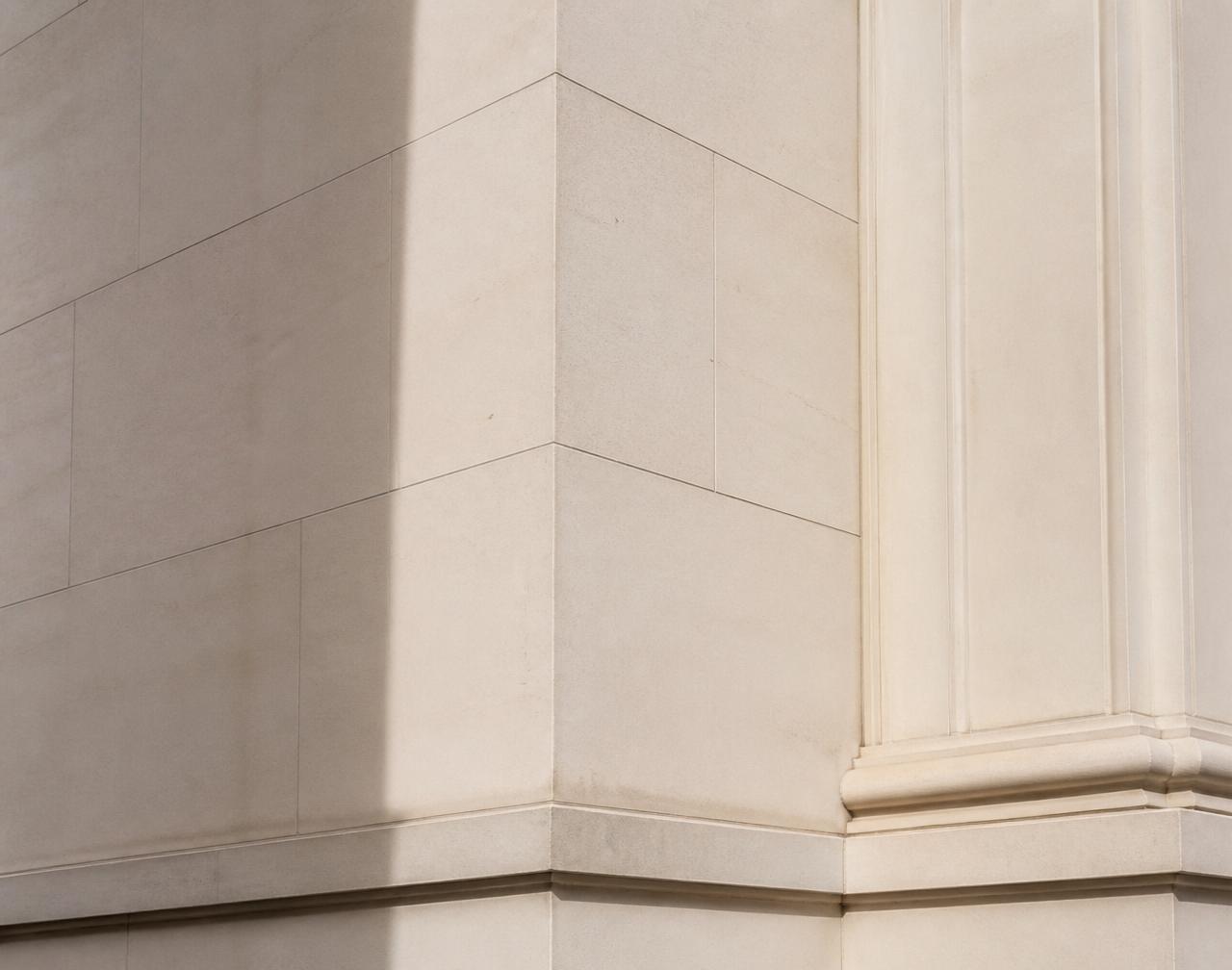 Detail of a pale limestone London facade in raking daylight